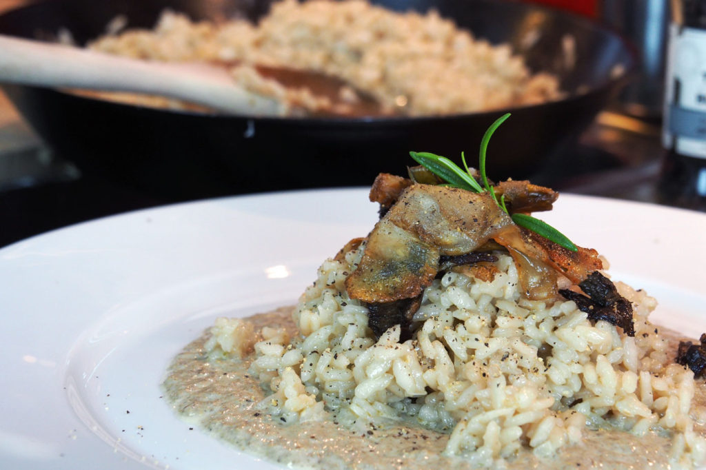 the finished chanterelle mushroom risotto topped with fried mushroom accompanied by mushroom cream