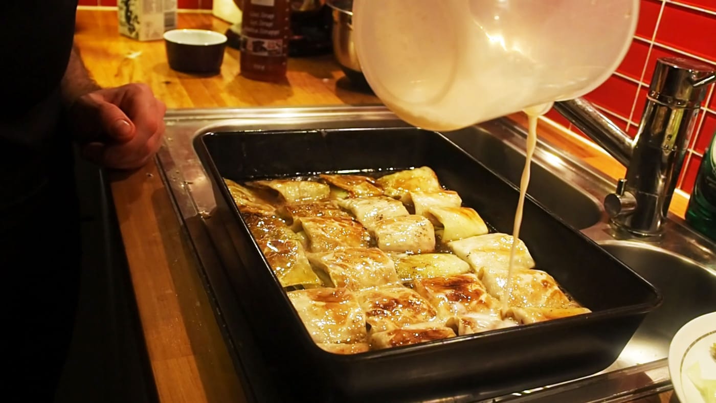 Pouring sauce onto kåldomar (stuffed cabbage rolls)