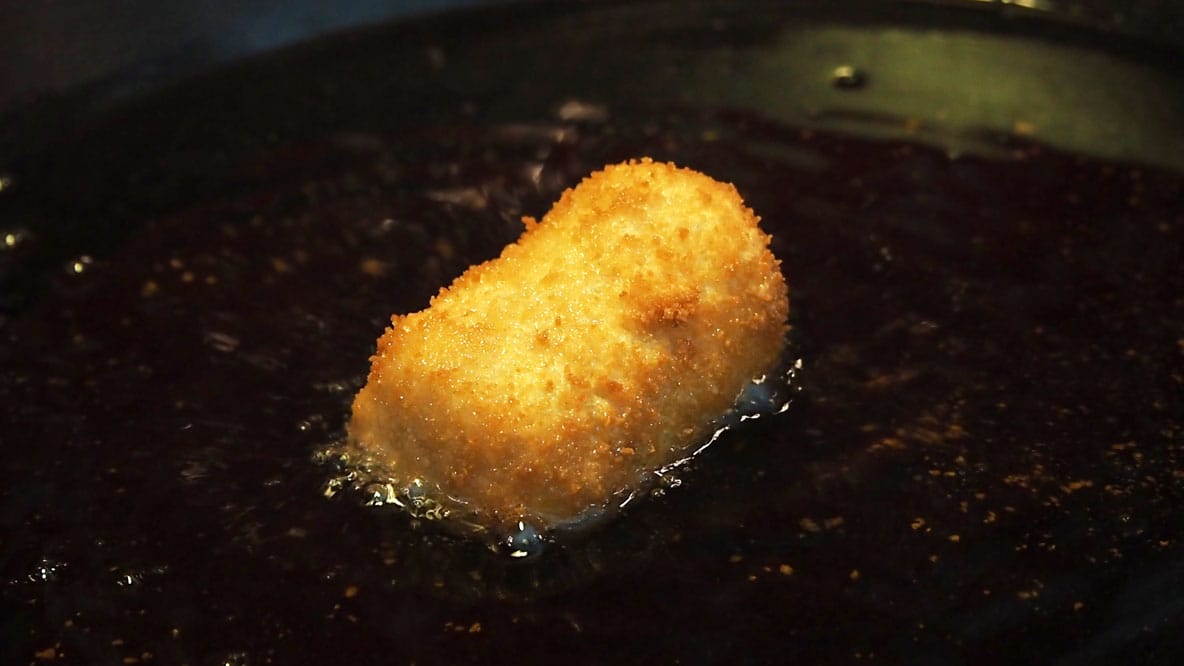 deep frying a piece of banana with dulce de leche