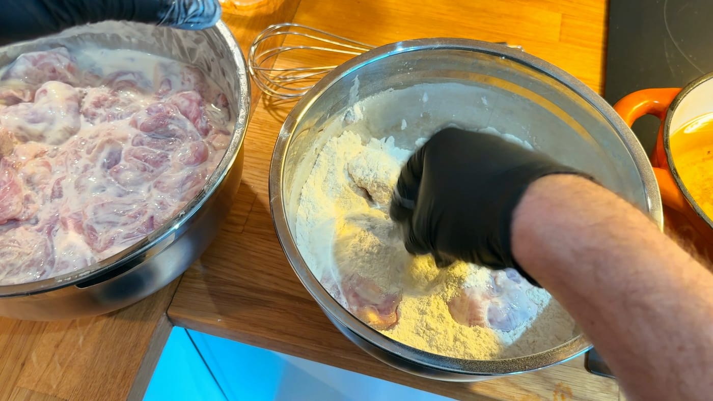 Dredging the marinated chicken in the flour mix