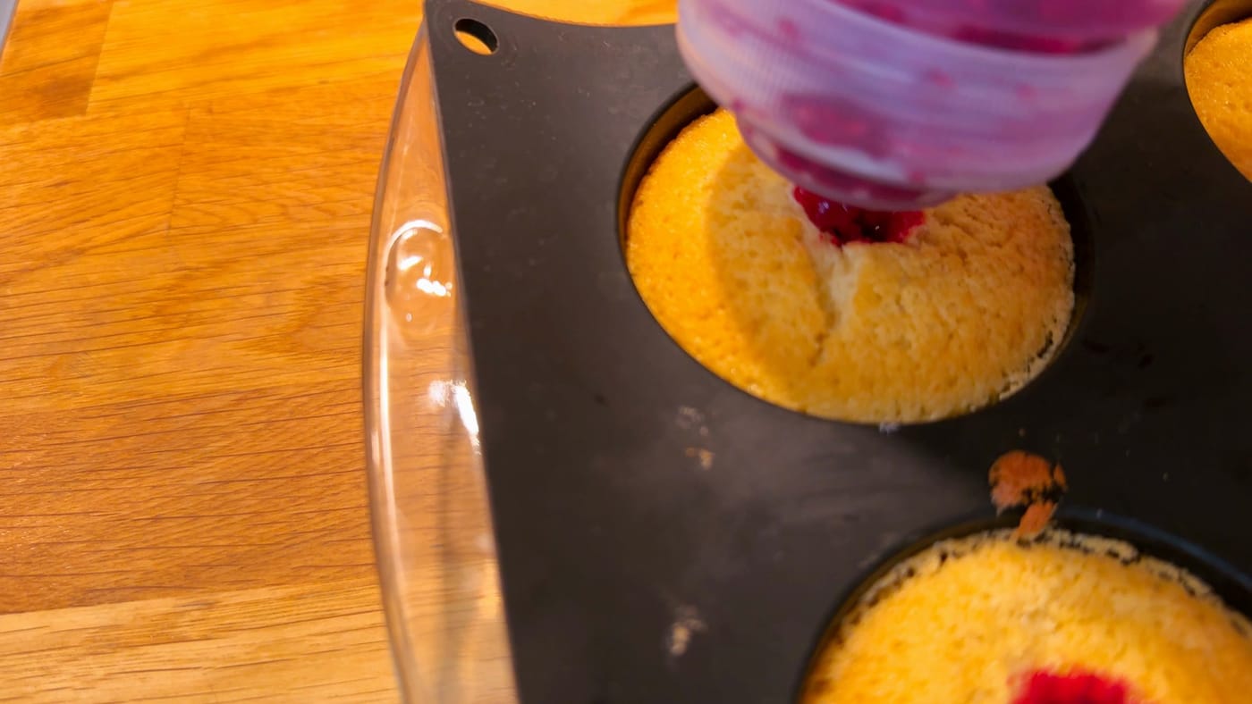 Raspberry jam squeezed into the middle of a cupcake