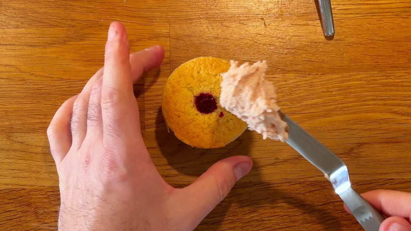 Pale pink cream spread on a cupcake